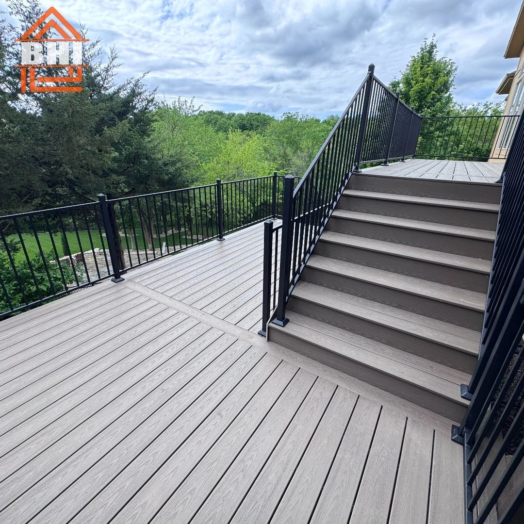 Multi-level composite deck with black aluminum railing and stairs built by Boyt Home Improvement