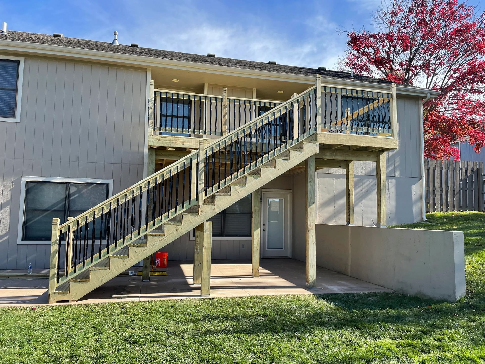 Two-story cedar deck with a staircase built by Boyt Home Improvement
